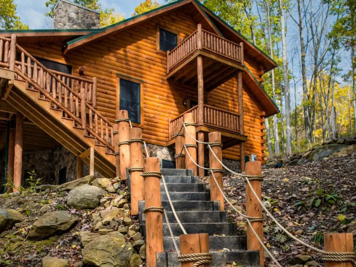 stairs up to log cabin with log railing and ropes