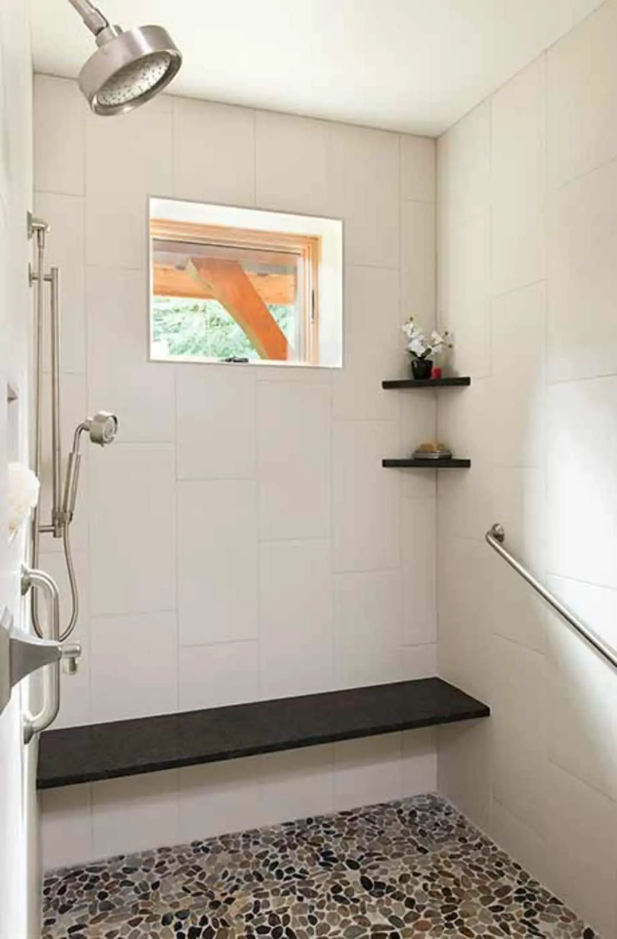 white tile lined shower with small window on upper wall